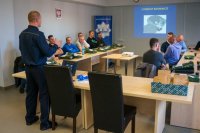 sala szkoleniowa, policjant prowadzi szkolenie z pierwszej pomocy medycznej
