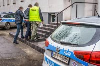 zdjęcie kolorowe, policjanci prowadzą zatrzymanego sprawcę rozboju