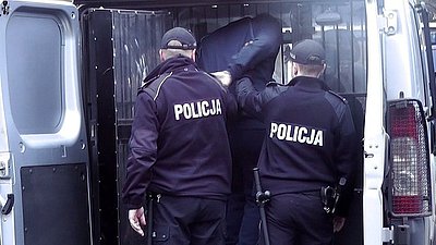 zdjęcie poglądowe, policjanci i zatrzymany przy samochodzie