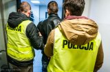 policjanci z zatrzymanym w korytarzu komendy