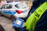 policjant z testerem narkotyków, w tle radiowóz