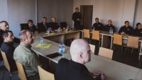 odprawa roczna - sala odpraw przy stołach siedzący policjanci, pracownicy cywilni i zaproszeni goście