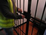 policjant przy kracie celi