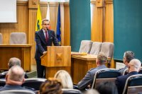 zdjęcie kolorowe przedstawia uroczystość pożegnania odchodzącego komendanta - sala sesyjna, zastępca prezydenta przemawia do komendanta i zaproszonych gości