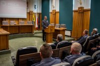 zdjęcie kolorowe przedstawia uroczystość pożegnania odchodzącego komendanta - sala sesyjna komendant przemawia przy mównicy