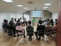 zdjęcie - sala wykładowa, uczniowie siedzą na krzesłach w okręgu