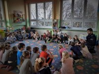 dzielnicowy czyta przedszkolakom książki o tematyce policyjnej