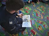 dzielnicowy czyta przedszkolakom książki o tematyce policyjnej