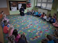 dzielnicowy czyta przedszkolakom książki o tematyce policyjnej