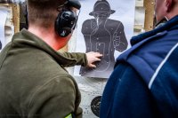 zdjęcie przedstawia zajęcia strzeleckie policjantów - policjant i instruktor przy tarczy