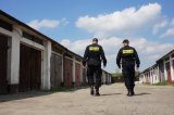policjanci patrolujący w tle garaże
