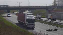 zdjęcie z nagrania wideo przedstawiającego ciężarówkę na drodze i motocyklistę, który się wywraca