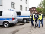 policjanci prowadzą zatrzymanego oszusta