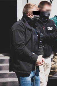 Policjant prowadzi zatrzymanego