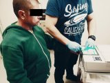 Technik kryminalistyki zabezpiecza odciski palców podejrzanego