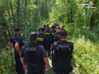 policjanci z oddziału prewencji w trakcie przeszukiwania lasu