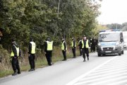 Widok policjantów udających się w stronę lasu.