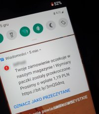 zdjęcie ekranu telefonu z wyświetlonym smsem