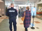 Widok policjanta i pracownika Państwowej Inspekcji Sanitarnej w trakcie kontroli.