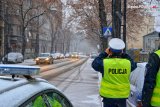 policjanci drogówki na drodze podczas opadów śniegu