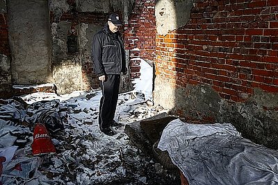 zdjęcie poglądowe - policjant wewnątrz opuszczonego budynku