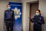 zdjęcie kolorowe z pożegnania nadkomisarza Dawida Gila - na zdjęciu zastępca komendanta i kadrowa odczytująca akt powierzenia obowiązków