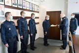 zdjęcie z ceremonii powierzenia obowiązków naczelnika - policjanci stoją, jeden z nich odbiera rozkaz z rąk komendanta wojewódzkiego