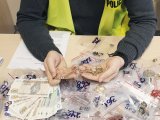 zarekwirowane wyroby jubilerskie - policjant trzyma w rękach złoty łańcuszek