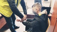 policjant zakłada kajdanki zatrzymanemu