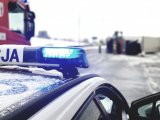 miejsce zdarzenia drogowego, radiowóz, straż i w tle leżąca ciężarówka - zdjęcie poglądowe