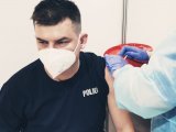 zdjęcie przedstawia moment szczepienia policjanta