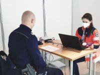 zdjęcie przedstawia policjanta i lekarkę w trakcie wywiadu przed szczepieniem