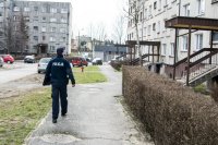 dzielnicowy idący chodnikiem na osiedlu