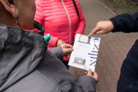 dzielnicowy wskazuje dane na ulotce kobiecie - zdjęcie archiwalne