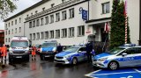 zdjęcie przedstawia policyjne radiowozy i karetki pogotowia oraz funkcjonariuszy oddających hołd zastrzelonemu policjantowi