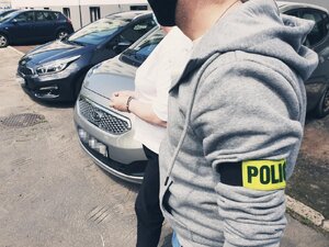 policjanci prowadzący kobietę przez parking rudzkiej komendy