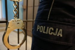 zdjęcie poglądowe - policjant, kraty, kajdanki