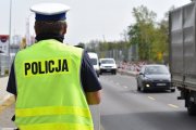 policjant drogówki na drodze, w tle samochody - zdjęcie poglądowe z archiwum policji