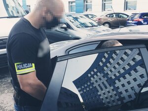 policjant kryminalny przy samochodzie