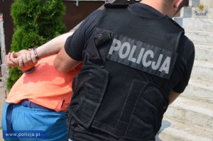 zdjęcie poglądowe - policjant prowadzi zatrzymanego