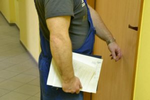 zdjęcie poglądowe, mężczyzna w ubraniu roboczym puka do drzwi