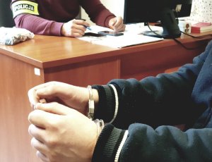 policjant i zatrzymany w kajdankach