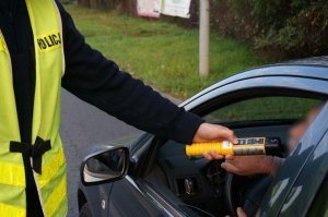policjant przeprowadzający badanie alkotestem - zdjęcie poglądowe z archiwum policji