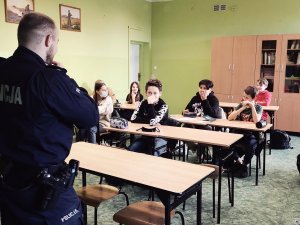 policjant w klasie z uczniami w trakcie prowadzenia zajęć