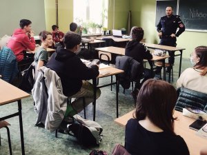 policjant w klasie z uczniami w trakcie prowadzenia zajęć