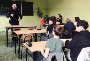 policjant w klasie z uczniami w trakcie prowadzenia zajęć