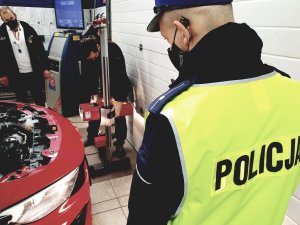stacja diagnostyczna - urządzenie do kontroli świateł pojazdu, samochód, policjant