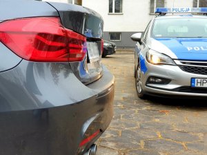 odzyskane bmw na policyjnym parkingu, w tle radiowóz