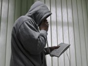 zdjęcie ilustracyjne - mężczyzna w kapturze trzyma telefon stacjonarny