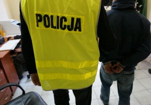 zdjęcie poglądowe - policjant prowadzi zatrzymanego